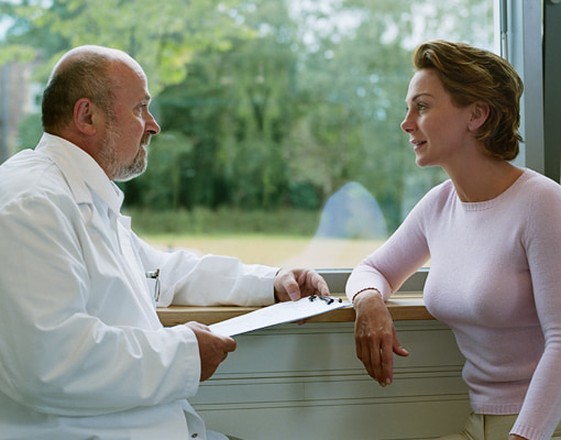Photo of male doctor talking to female patient
