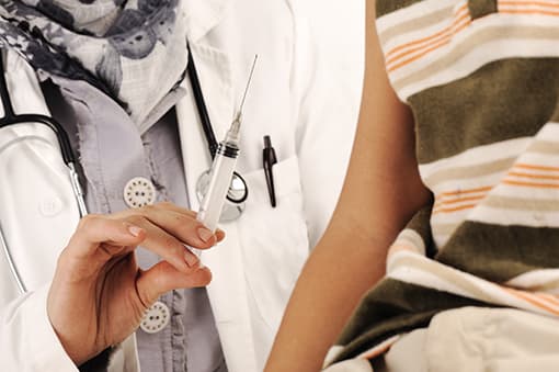 Photo of doctor giving an injection to a young patient