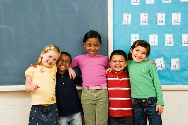 Image of various ethnic children lined up in front of the class