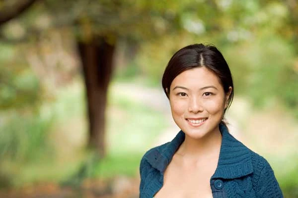 Young Asian woman smiling while facing the camera. She